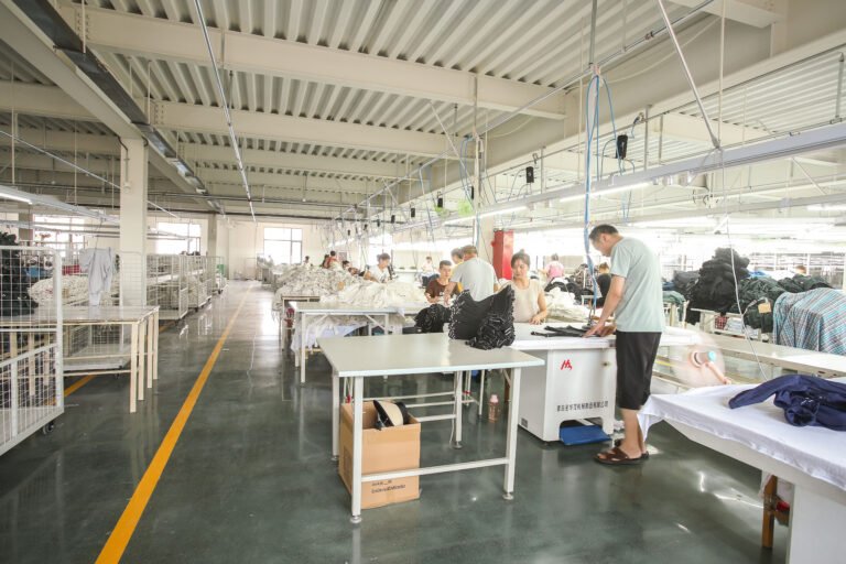 Workers handling garment panels in a garment production area