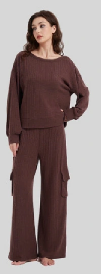 Woman wearing a brown long-sleeve top and wide-leg trousers with pockets