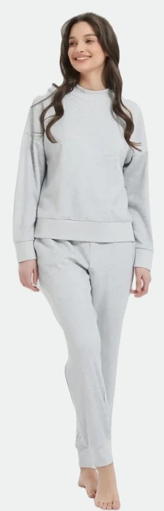 Woman wearing a light grey crewneck sweatshirt and matching trousers