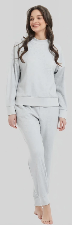 Woman wearing a light grey crewneck sweatshirt and matching trousers