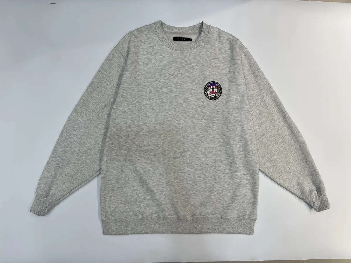 Grey crewneck sweatshirt with raglan sleeves laid flat