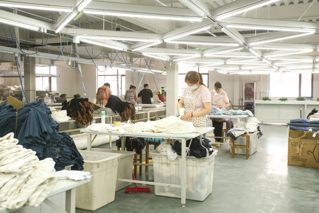 Jiajia staff reviewing garments on the production floor