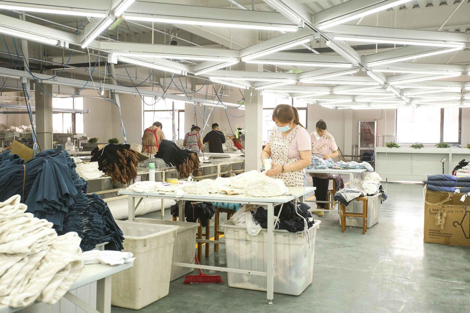 Jiajia staff reviewing garments on the production floor