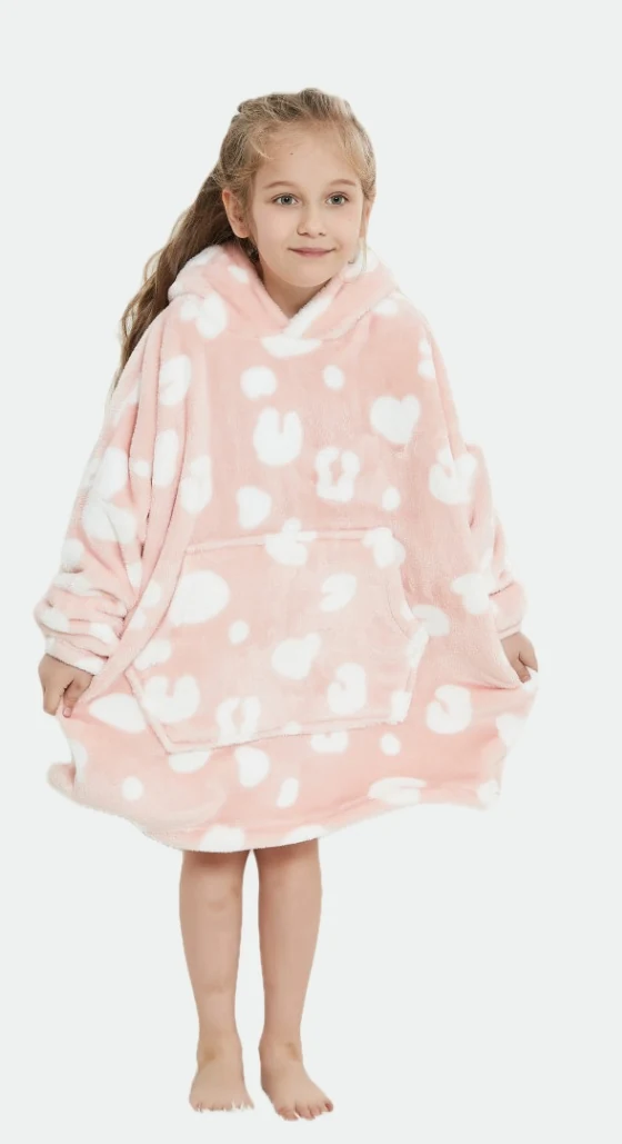 Child wearing a loose pink heart-print hooded blanket with a front pocket