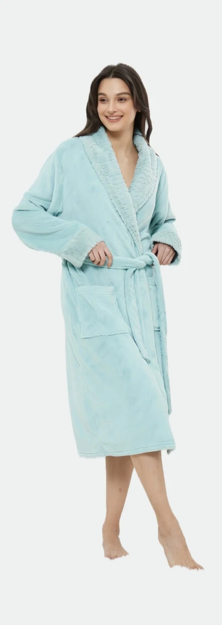 Standing woman wearing a light blue-green belted robe with pockets