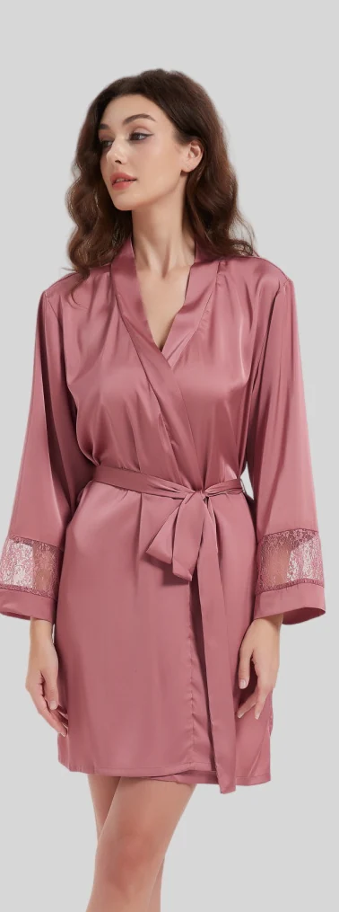 Woman wearing a dusky-pink short belted robe with lace sleeve details